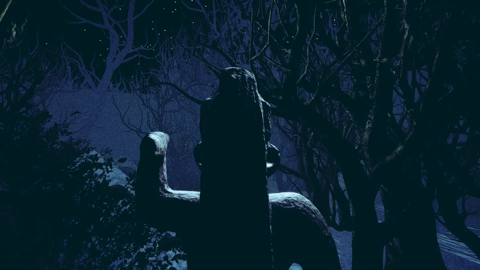 Dark night forest with a carved wooden statue partly hidden among bare branches